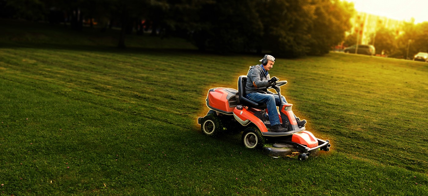 Image of a person sitting on a lawn mower with a yellow glow surrounding the machine